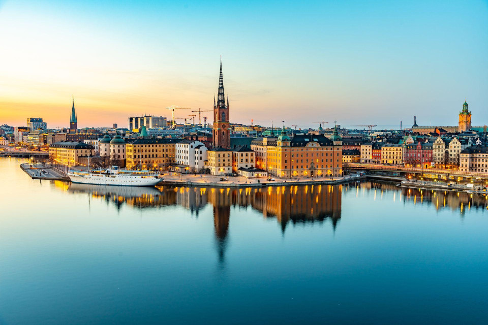 <p class="isSelectedEnd">Stockholm greeted us with sunlight dancing across the water. Built on fourteen islands, the Swedish capital seemed to float between Lake M&auml;laren and the Baltic Sea, connected by elegant bridges, ferries and narrow streets that invited us to keep exploring.</p>
<p class="isSelectedEnd">We began in Gamla Stan, the historic heart of the city. Behind its colourful fa&ccedil;ades, every street seemed to hold a story. We wandered past the Royal Palace, stepped into small design shops and followed cobbled lanes until we reached Stortorget, the city&rsquo;s oldest square. Sitting outside with coffee and a warm cinnamon bun, we watched Stockholm move around us&mdash;calm, stylish and wonderfully unhurried.</p>
<p class="isSelectedEnd">From there, we crossed the water to Djurg&aring;rden. The ferry ride took only a few minutes, yet it felt as if we had left the city behind. Trees, gardens and quiet walking paths surrounded some of Stockholm&rsquo;s most fascinating museums. At the Vasa Museum, we stood beneath a seventeenth-century warship that sank on its first voyage and was raised from the seabed more than three centuries later. Nearby, the open-air museum of Skansen offered a journey through Swedish history, complete with traditional houses, craftsmen and Nordic animals.</p>
<p class="isSelectedEnd">But Stockholm&rsquo;s charm is not found only in its monuments. It lives in the ritual of fika, in the confidence of Scandinavian design and in the way nature is woven into everyday city life. In S&ouml;dermalm, vintage stores, creative studios and cosy caf&eacute;s filled the streets. From the heights of Monteliusv&auml;gen, we looked back across the water at the towers and rooftops of Gamla Stan, glowing in the evening light.</p>
<p class="isSelectedEnd">Later, we boarded another ferry without checking exactly where it would take us. That is perhaps the best way to experience Stockholm: moving slowly from island to island, letting the water guide you.</p>
<p class="isSelectedEnd">As the sun began to set, the city turned golden. Boats passed silently beneath the bridges, locals gathered along the waterfront and the sky reflected perfectly in the harbour. Stockholm felt elegant but never distant, historic yet unmistakably modern.</p>
<p>It is a capital that does not demand your attention. It quietly earns it: one island, one cinnamon bun and one beautiful waterside view at a time.</p>
<p><em>Jessica M&ouml;nderville (Germany)</em></p>